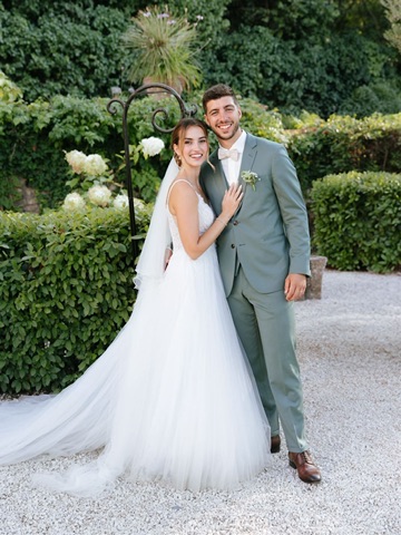Couple de mariés posant ensemble dans un jardin