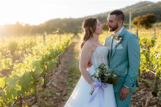 Couple de mariés se regardant au coucher du soleil dans les vignes