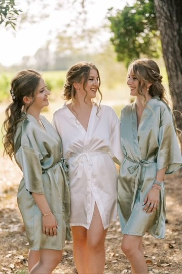 Trois femmes en peignoirs de satin dans un jardin
