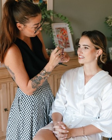 Laura échange avec une cliente en peignoir blanc pendant sa préparation
