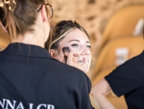 Application du blush pendant la préparation d’une cliente