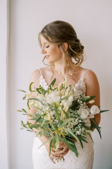 Mariée tenant un bouquet de fleurs blanches